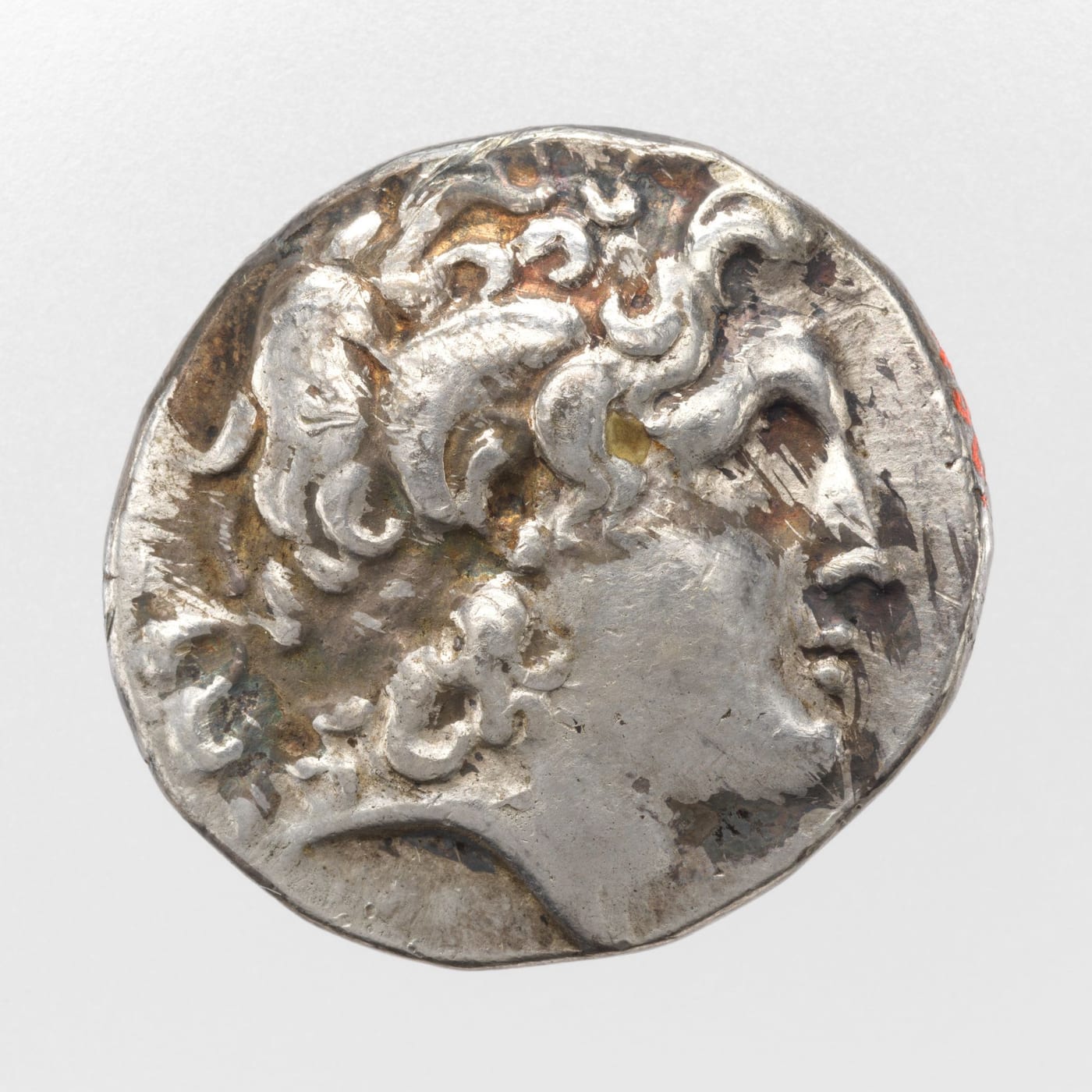Silver coin with the head of Alexander the Great in profile, his hair in thick curls